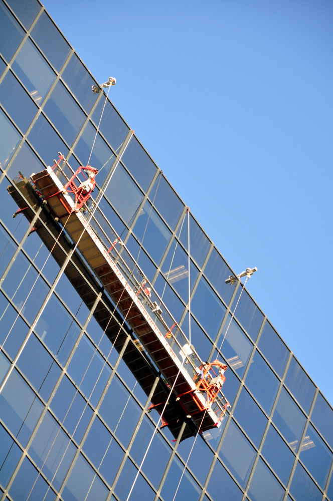 Tall building with scaffolding hanging on the side