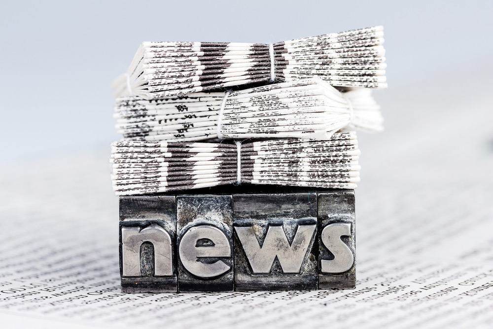 stock photo of newspaper stacks laying on top of a block with the words news