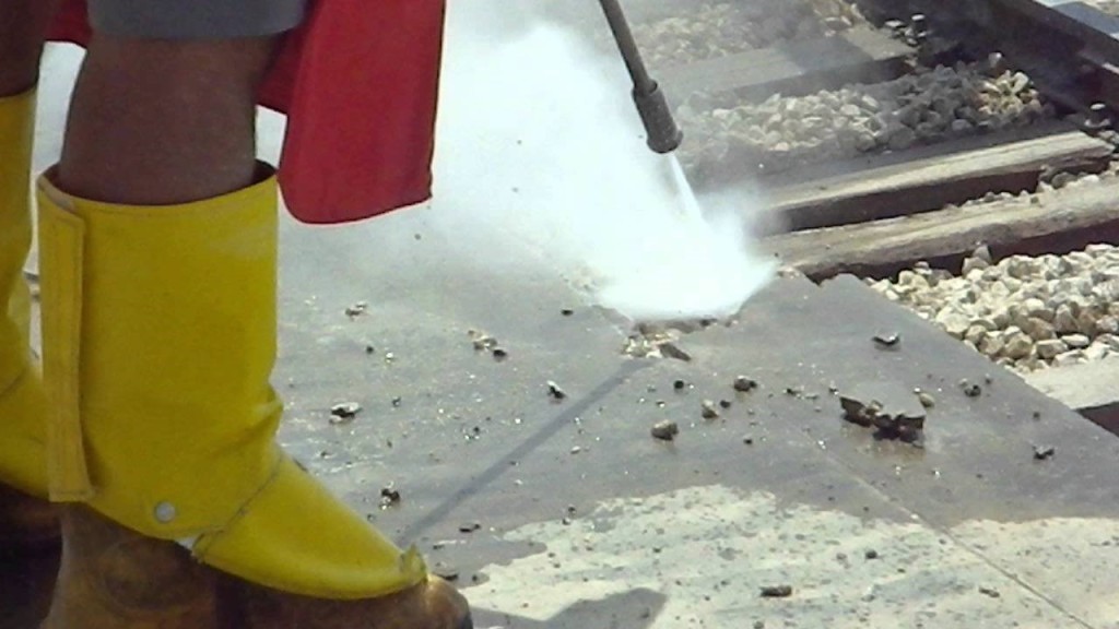 Worker power washing concrete